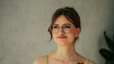 Junge Frau mit eckiger ENNY Damenbrille in Blau-Gold – moderner, eleganter Look mit feiner Linienführung und klarer Ausstrahlung