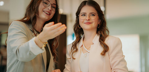 Zwei Mitarbeiterinnen von Barth Optik im liebevollen Gespräch – ehrlicher Austausch und herzliches Miteinander im Team.