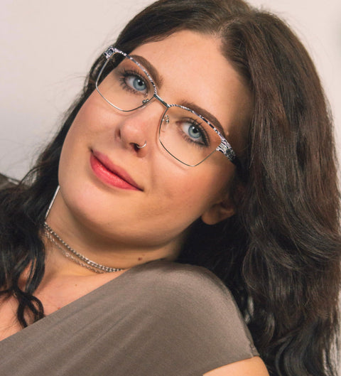 Model trägt eckige Damenbrille mit Schlangenmuster und silbernen Details im extravaganten Look