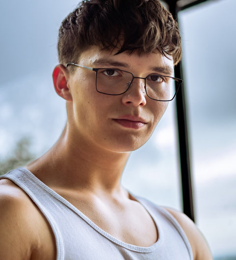 Herrenbrille in Dunkelgrün-Silber mit eckiger Form, zeitloses Design aus Flexmetall, getragen im sportlich-lässigen Outdoorlook.