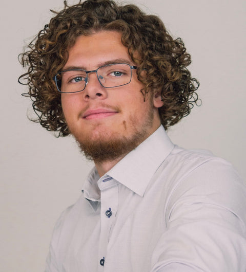 Model trägt eckige schwarz-blaue Herrenbrille im Business-Look mit Hemd