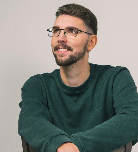 Model trägt eckige schwarze Herrenbrille mit grünen Details im Alltag