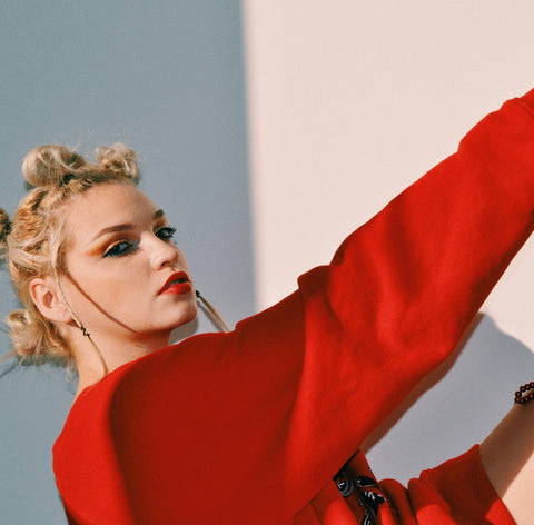 Frau mit auffälliger Frisur & rotem Kleid – ausdrucksstark & stilbewusst mit ENNY-Brille.