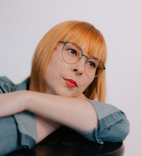 Model trägt runde Damenbrille mit Farbverlauf Blau-Gold im Vintage-Stil