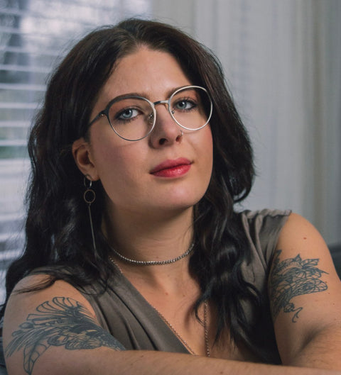 Model trägt runde Damenbrille mit Farbverlauf Grau-Silber im Vintage-Look am Fenster