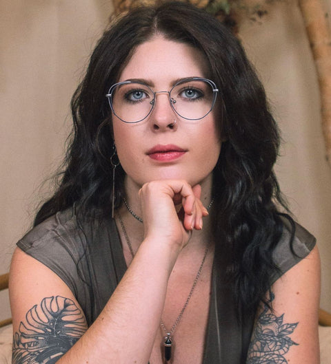 Model trägt extravagante Schmetterlingsbrille in Blau mit mattem Silber im stilvollen Look