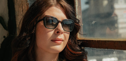 Frau mit ENNY-Sonnenbrille im Sonnenlicht – modisches Statement mit optischem Anspruch für dein Seherlebnis.