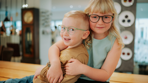 Zwei lachende Kinder mit modernen Kinderbrillen bei Barth Optik – fröhlich, farbenfroh und gut versorgt mit perfekter Passform