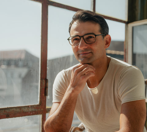 Selbstbewusster Mann mit eckiger, dunkler ENNY Herrenbrille am sonnigen Fenster – moderner Look für Büro & Alltag