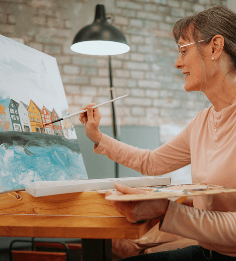 Frau mit Brille malt an Leinwand – präzises Sehen mit SOON.