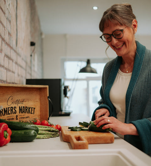 Frau freut sich über ihre Gleitsichtbrille beim Gemüse schneiden
