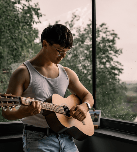 Mann mit Brille spielt Gitarre – harmonisches Sehen mit SOON.