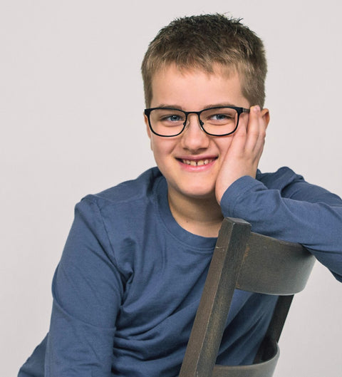 Junge trägt eckige schwarze Kinderbrille Kian mit bunten Details im Alltag