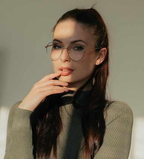 ENNY Glückskind Brille in Grau-Grün – runde, zarte Metallfassung mit Vintage-Flair am Modell im sanften Licht