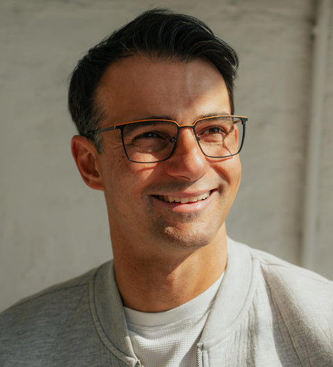 ENNY Lebenslust Herrenbrille in Schwarz-Orange – sportlich-eckige Metallfassung mit farbigem Akzent am Modell im Sonnenlicht