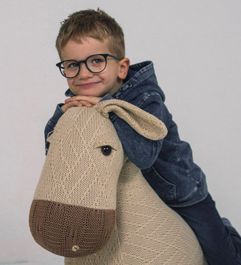 Junge trägt runde Kinderbrille in Blau mit türkiser Innenseite beim Spielen