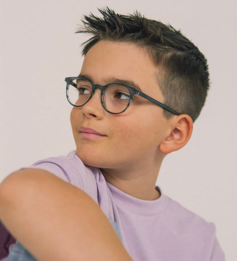 Junge trägt matte runde Kinderbrille in Grau mit melierter Struktur im Alltag