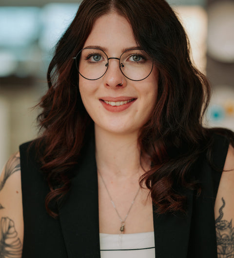 ENNY Scharfsinnig Brille in Schwarz – runde, zarte Unisex-Metallfassung im Vintage-Stil am Modell im Innenraum